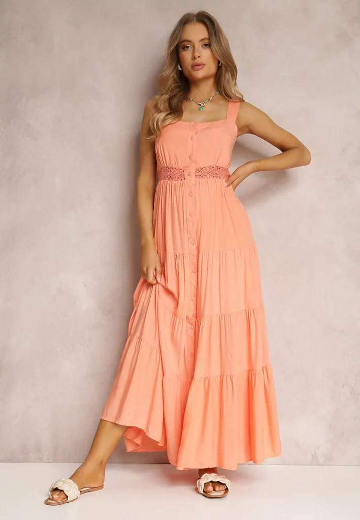 Długa brzoskwiniowa sukienka na ramiączkach z ozdobnymi guzikami i koronką.