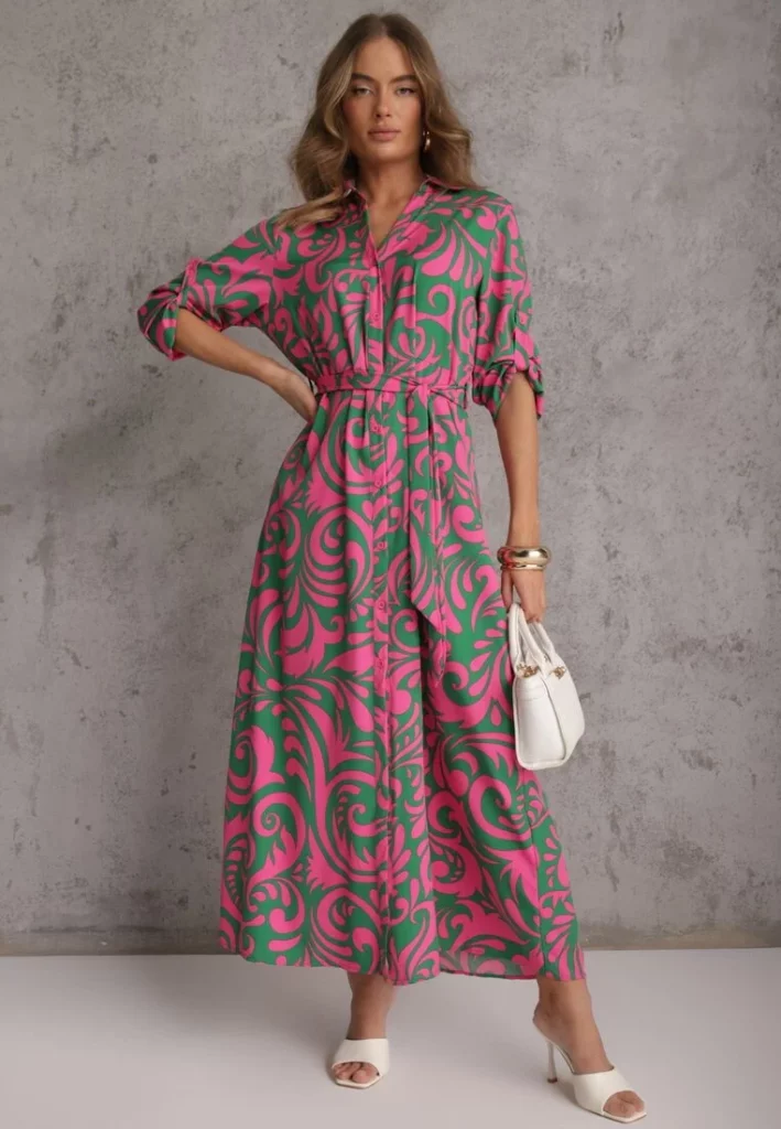 Modelka prezentuje różowo-zieloną sukienkę koszulową maxi w abstrakcyjny print.