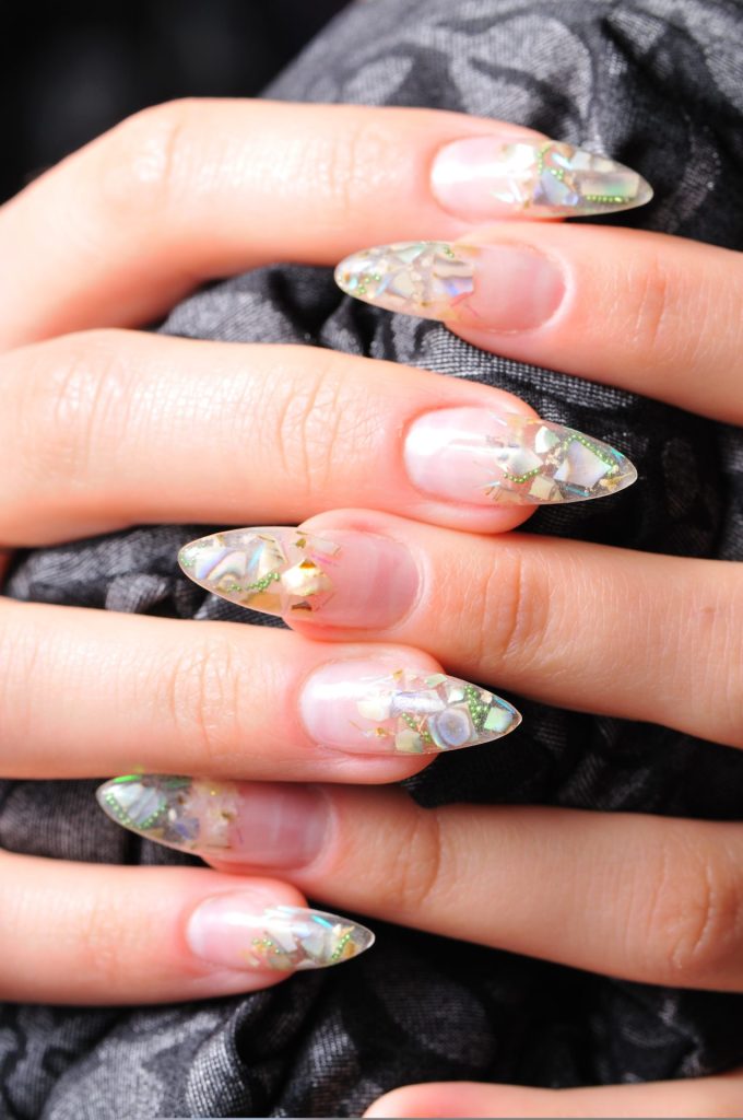 Półtransparentne paznokcie z kryształkami zatopionymi w żelu.