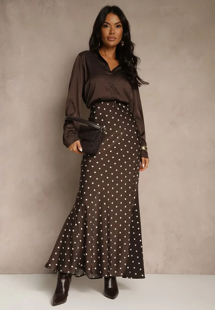 Modelka prezentuje elegancką spódnice w groszki w kolorze brązowym. 