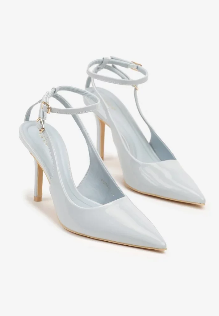 Buty sandały lakierowane ze złotymi elementami na białym tle. 