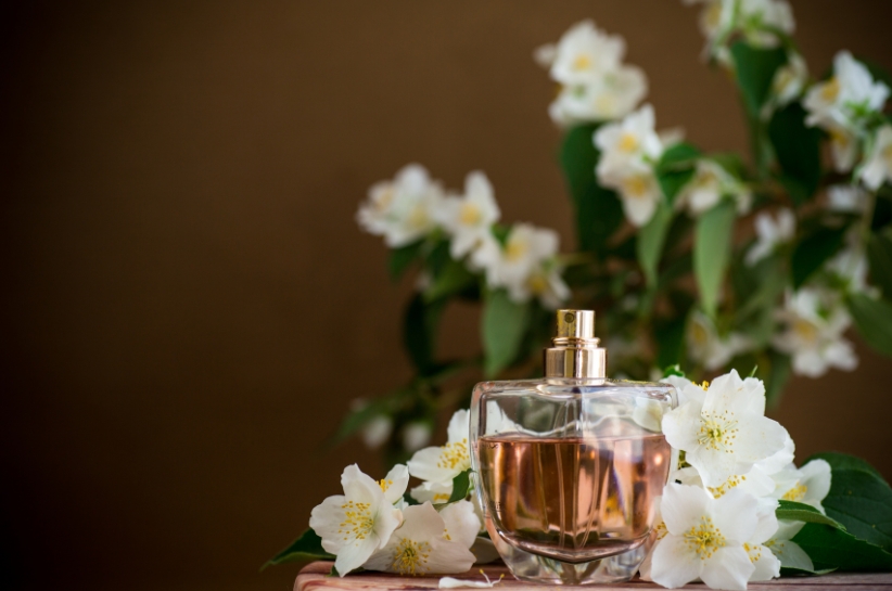flakon perfum na tle białych kwiatów